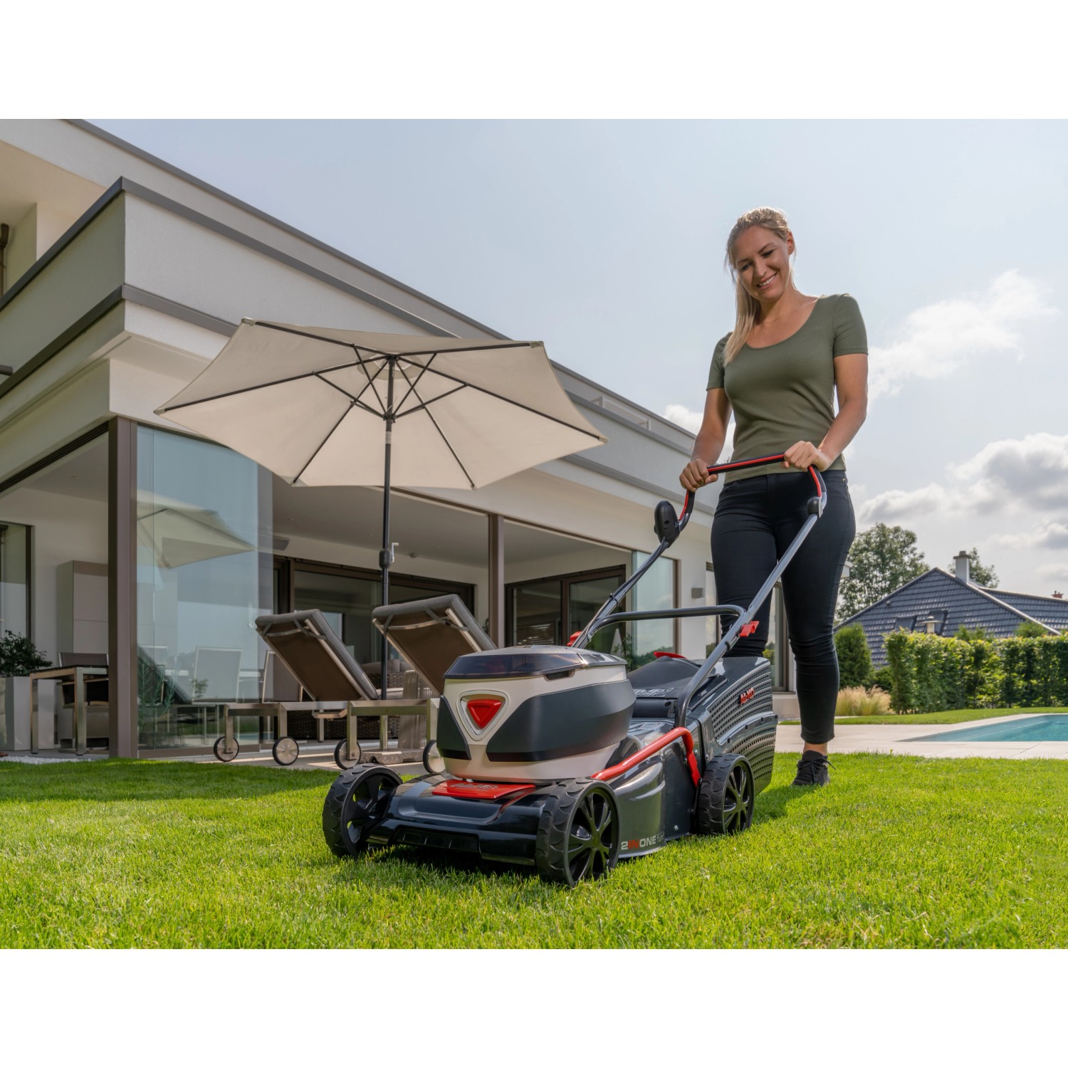 Frau bedient Al-Ko Akku-Rasenmäher 42.2 Li Comfort im Garten.