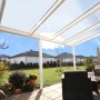 Weiße Terrassenüberdachung Garda aus Aluminium mit klarer Polycarbonat-Dacheindeckung.