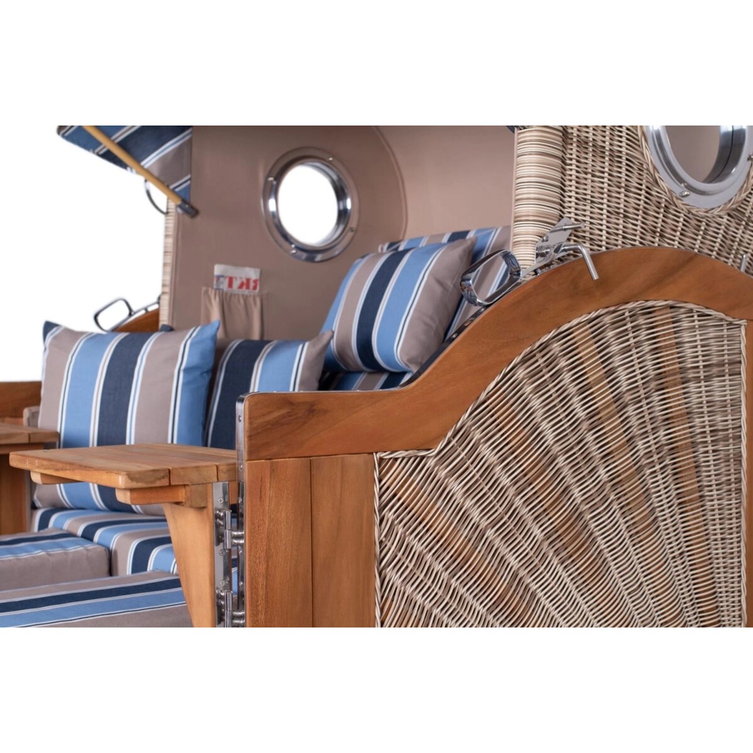 Detailansicht des Teak Strandkorbs Ammersee Grande XL mit Bullauge, Tisch und blau-gestreiften Kissen.