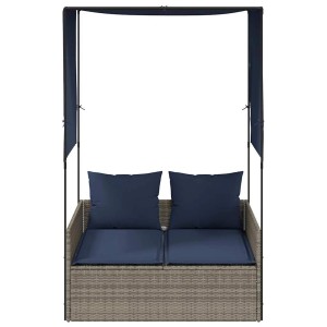 Graue Poly-Rattan Doppelliege mit Dach, Vorhängen und marineblauen Kissen. Ideal für Garten & Terrasse.