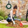 Schwarzer Relaxdays Schlauchhalter aus Stahl an einer Steinwand, mit aufgerolltem grünem Gartenschlauch. Platzsparende Wandaufhängung für Garten.