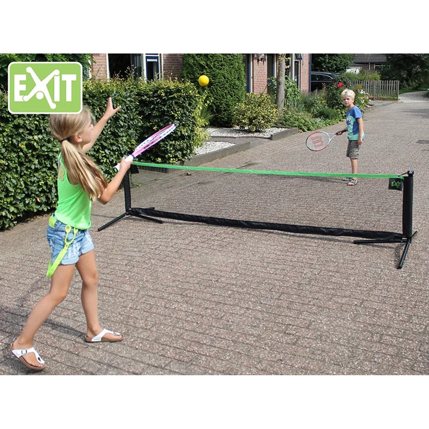 Schwarzes, verstellbares EXIT Sportnetz (155x300cm) beim Tennisspiel im Garten.
