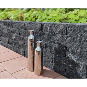 Diephaus Mauerstein Maximo Brista Schwarz als Gartenmauer mit Deko-Vasen.