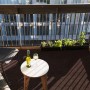 Primaflor Rasenteppich Green Braun auf Balkon mit Tisch und Stuhl, stimmungsvolle Atmosphäre.