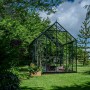 Freistehendes, grünes Halls Gewächshaus Icon Planthouse 8 im Garten.
