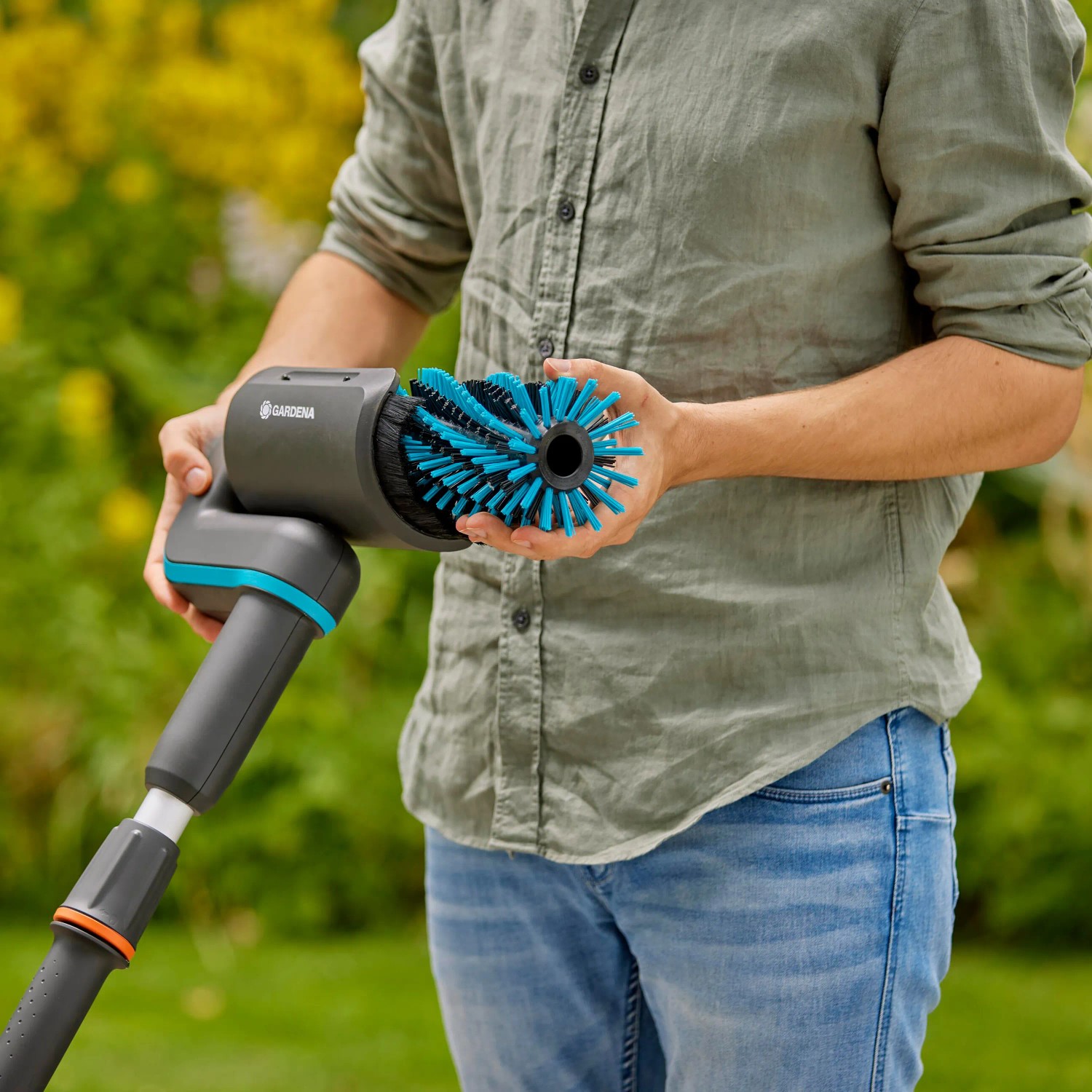 Gardena Akku-Multi-Reiniger AquaBrush Patio mit rotierender Bürste in Aktion.