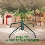 Stabiler grüner Metall-Standfuß eines künstlichen Weihnachtsbaums mit grünen Nadeln und Geschenken im Hintergrund.