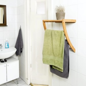 Relaxdays Wandhandtuchhalter aus Bambus und Chrom mit Ablage. Zwei Handtücher hängen im Bad an den Stangen.