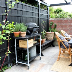 Schwarzes Nadelholz Gartentor Rustik (100x180cm) als Teil einer Gartenszene mit Grill und Sitzmöbeln.