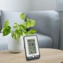 Schwarze TFA Funk-Wetterstation Multi mit Display auf Tisch. Wetterprognose und Funkuhr.