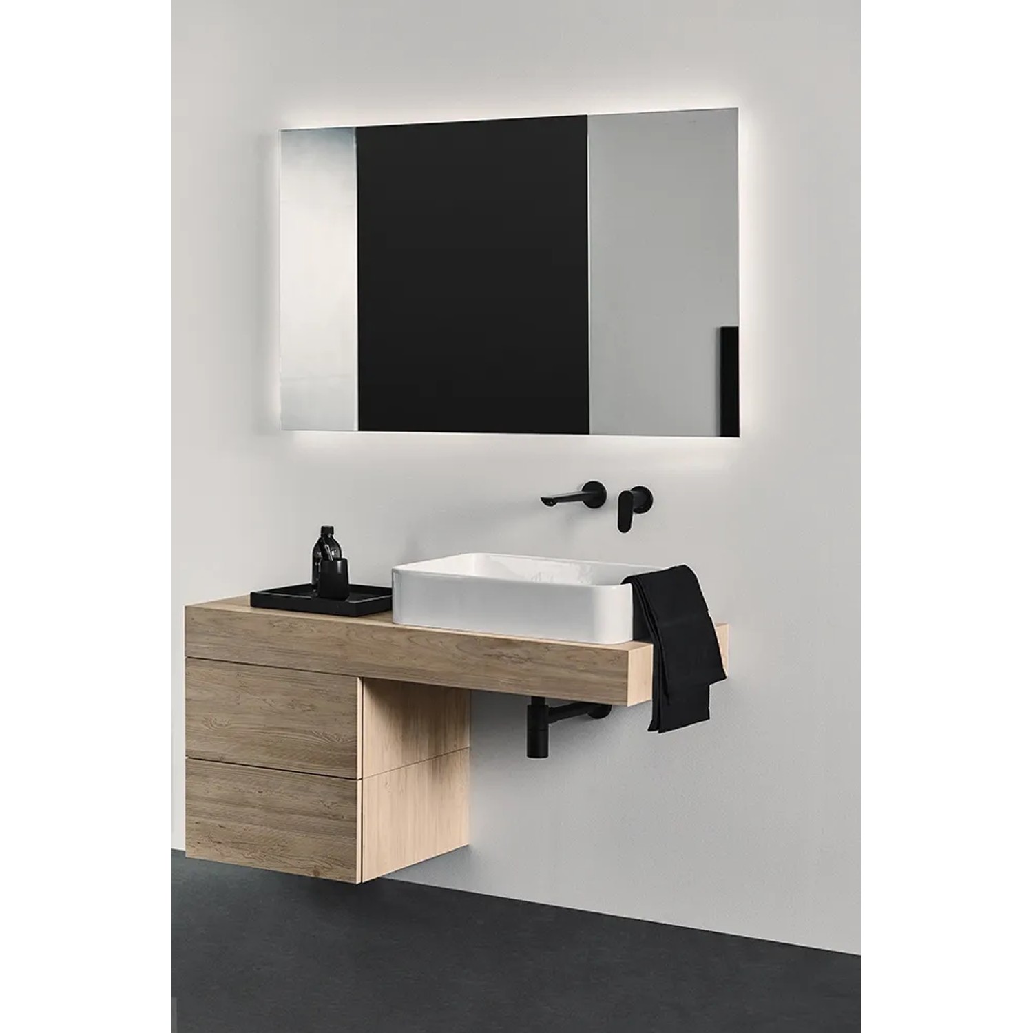 Ideal Standard Designsiphon G 1 1/4, schwarz matt, unter einem Waschbecken im modernen Bad.