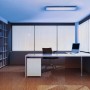 Moderne Büroeinrichtung mit Ledvance LED-Deckenleuchte Planon Plus, Bücherregal und Schreibtisch.