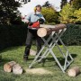 Mann sägt Holz auf klappbarem, verzinktem Sägebock mit 3 Stammhaltern im Garten. Robuste Sägehilfe für Holzarbeiten.