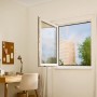 Geöffnetes Fenster mit anthrazitfarbenem tesa® Insect Stop Fliegengitter in Wohnraum-Szene.