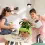 Lechuza Ojo Pflanzgefäß in Apfelgrün mit Kindern beim Gießen einer Pflanze.