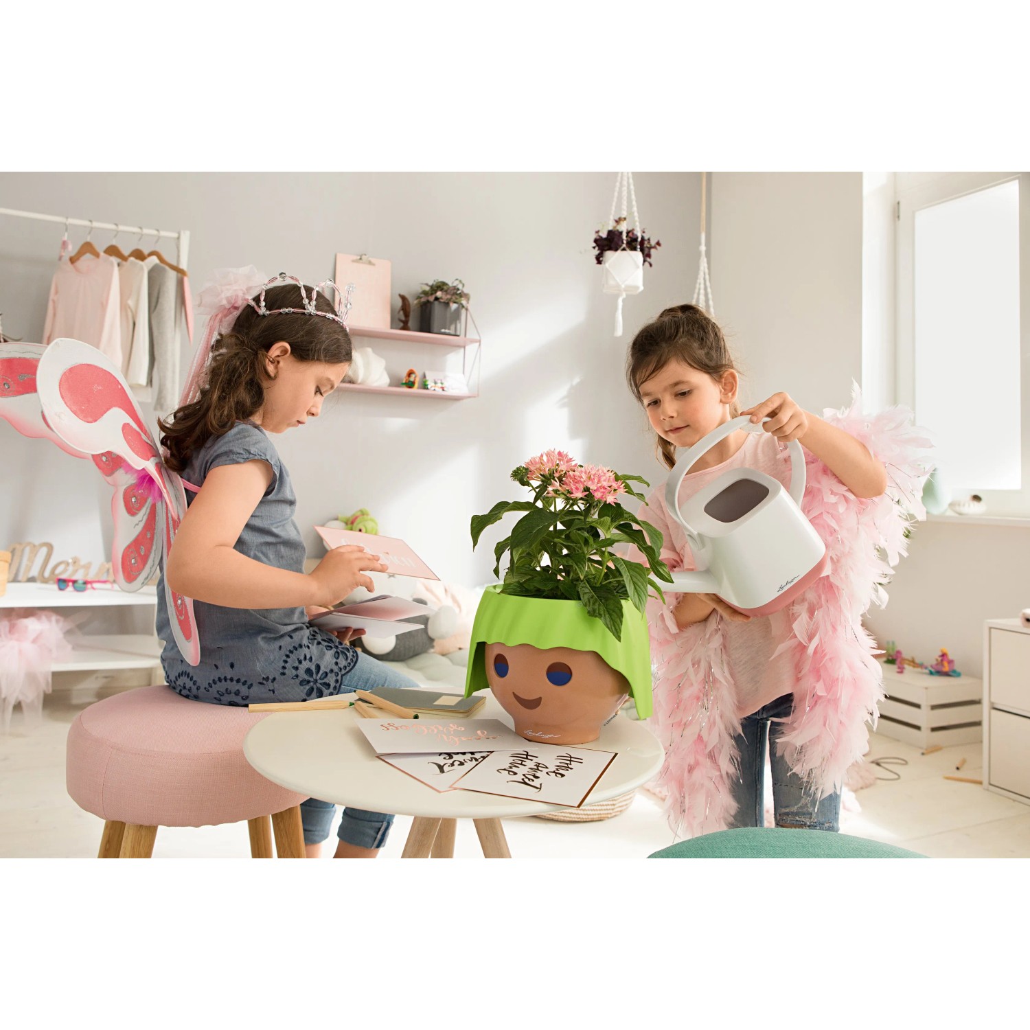Lechuza Ojo Pflanzgefäß in Apfelgrün mit Kindern beim Gießen einer Pflanze.