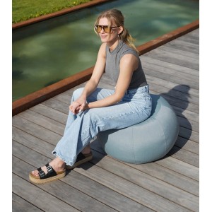 Frau sitzt auf blauem mokebo Outdoor Pouf 'Der Kugelige' 60x45cm auf Holzterrasse.