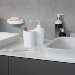 Weißer Spirella Zahnputzbecher Lemon Opaque mit Zahnbürste und Zahnpasta im Badezimmer.