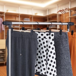 Hosenbügel aus Lotusholz und schwarzem Metall mit verstellbaren Clips für Röcke und Hosen im Kleiderschrank.