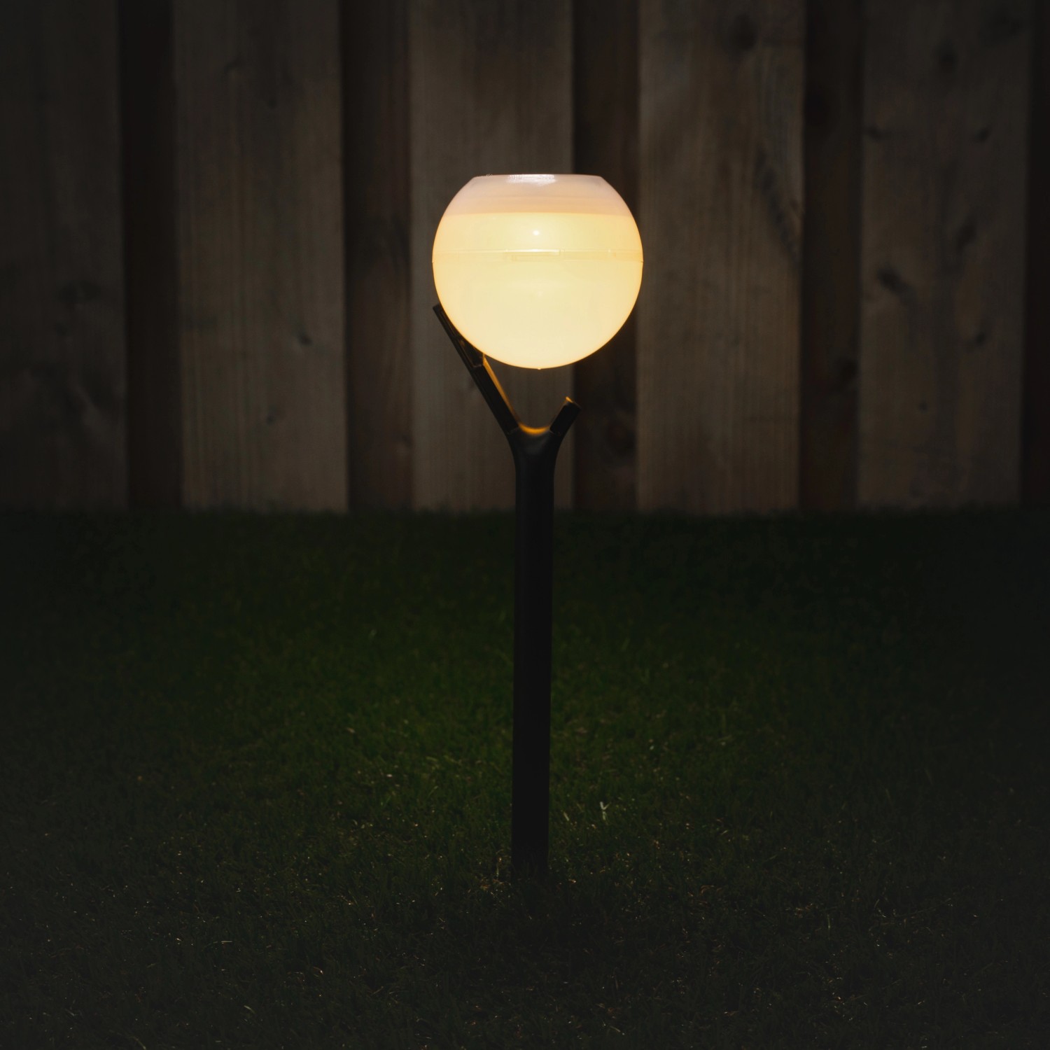 Weiße Solarleuchte Kaapstad mit Erdspieß im Garten, warmweißes Licht.