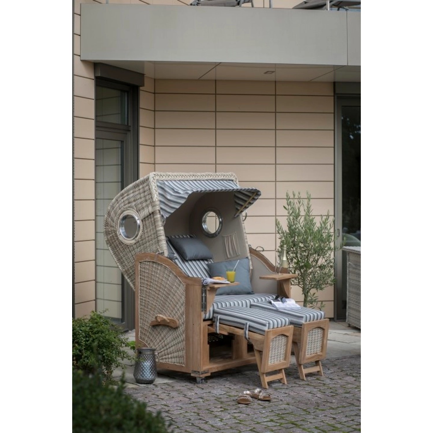 GarWoh Strandkorb Rantum Teak mit PE-Geflecht und blau-weiß gestreiftem Dessin.