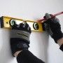 TECH-CRAFT Wasserwaage in Nutzung mit Handschuhen und Stift an einer Wand.