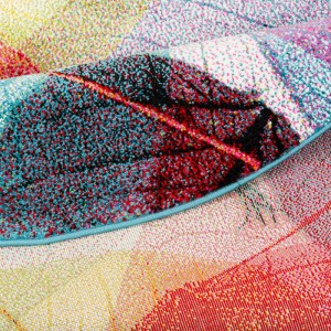 Detailansicht des bunten, runden Designer Teppichs Faro Tropical mit Blättermuster.