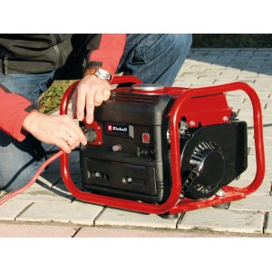 Einhell Notstromaggregat TC-PG 10 E5: Mobiler Stromerzeuger mit rotem Tragegestell und Person beim Einstecken.