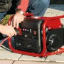 Einhell Notstromaggregat TC-PG 10 E5: Mobiler Stromerzeuger mit rotem Tragegestell und Person beim Einstecken.