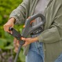 Frau bedient Gardena Akku-Rasentrimmer EasyTrim 25/18V mit Akku im Garten.
