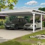 Weißer Skan Holz Doppelcarport Emsland mit zwei parkenden Autos im Garten.