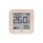 Shelly Temperatur Sensor Plus H&T G3 in Hellbeige zeigt Temperatur, Luftfeuchtigkeit und Uhrzeit an.