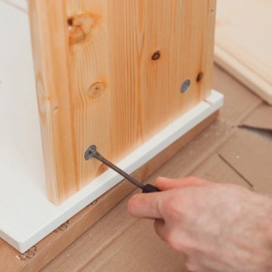 Hand schraubt verzinkte Schraube in Holzmöbel. Schrauben Set von CCLIFE.