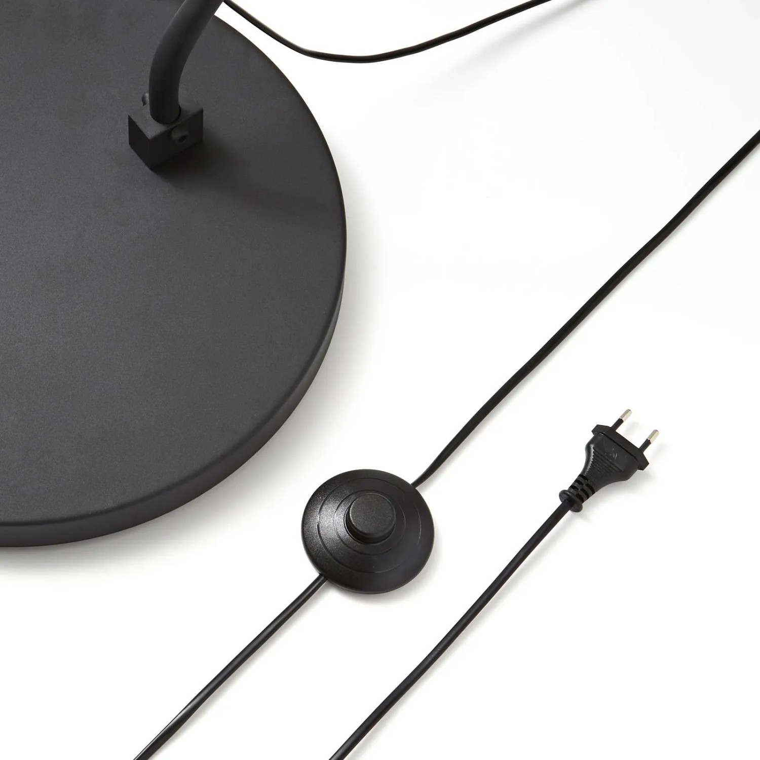 Detailaufnahme der schwarzen Lindby Bogenleuchte Jonera: Fuß, Kabel und Schalter.
