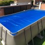 Blaues Summer Fun Pool-Solarfolie auf Rechteckpool, schützt vor Verschmutzung und speichert Wärme.