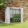 Weißes Outsunny Gewächshaus mit Rolltür und Fenster, an eine Mauer gelehnt, mit Pflanzen darin.
