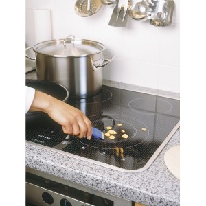 LUX Universalschaber im Einsatz zum Reinigen eines Ceranfelds von Speiseresten.