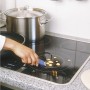 LUX Universalschaber im Einsatz zum Reinigen eines Ceranfelds von Speiseresten.