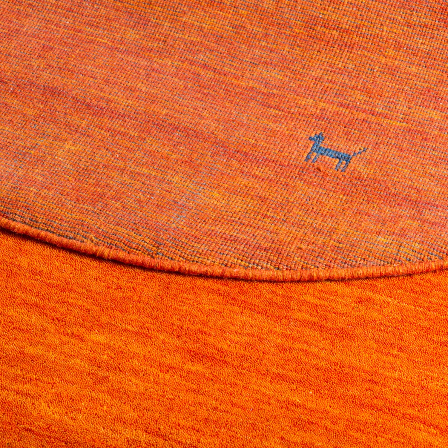 Detailansicht: Runder, terrakottafarbener Nepal Gabbeh Teppich (150cm) mit Hunde-Motiv.