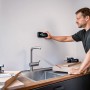 Mann benutzt Bosch Professional Ortungsgerät GMS 120-27 an einer Wand in der Küche.