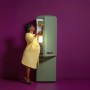 Frau öffnet grünen Kühlschrank, beleuchtet durch WiZ Smart LED Leuchte.