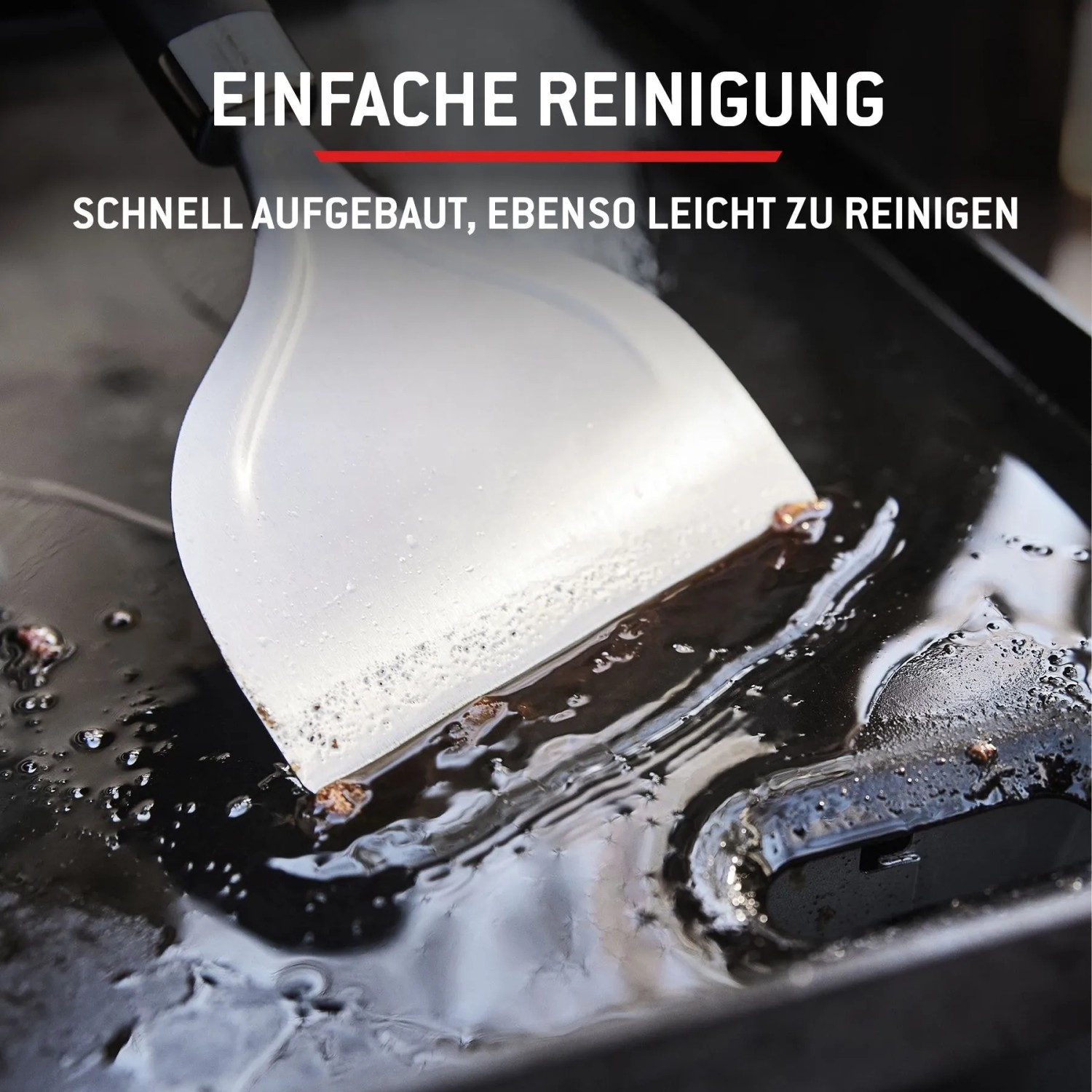 Reinigung des Weber Gasgrills Slate: Spatel schiebt Speisereste auf der Plancha zusammen.