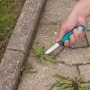 Wolfcraft Outdoormesser mit gezahnter Klinge im Einsatz zum Unkraut entfernen.