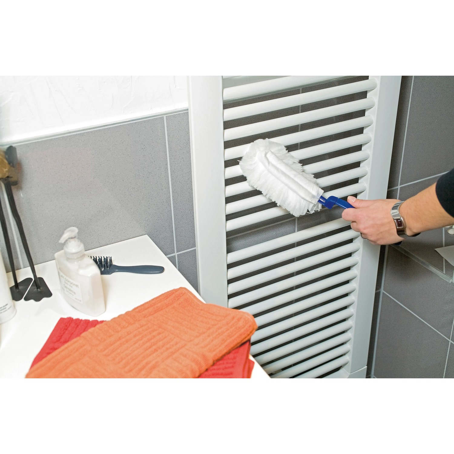 Staubfanggerät Mikrofaser im Einsatz zum Reinigen eines Heizkörpers im Badezimmer.