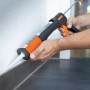 OBI Kartuschenpresse in Anwendung: Mann dichtet Fuge mit Silikon ab. Maurerwerkzeug für präzises Arbeiten.