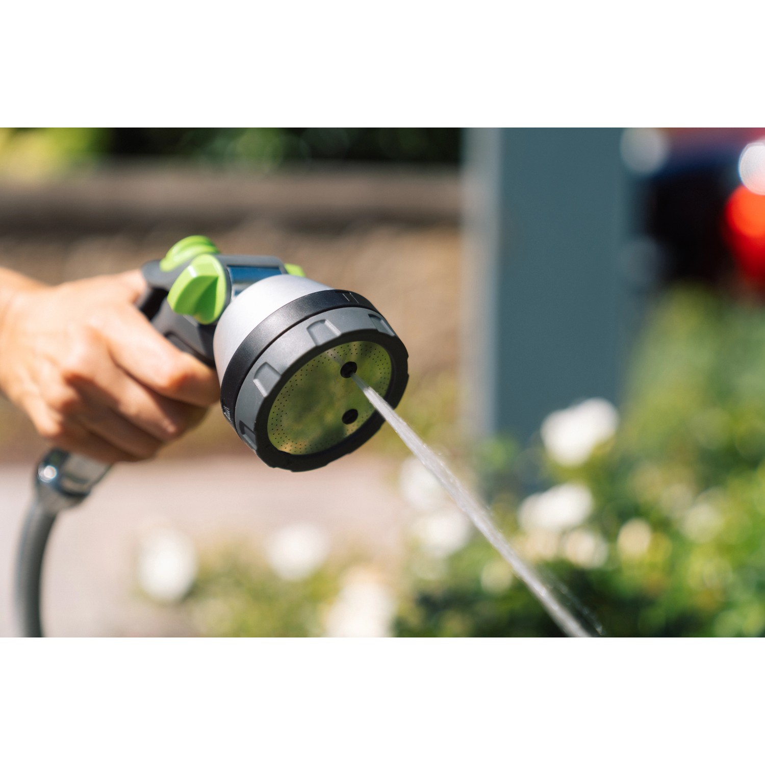 Geka Multibrause Plus 3S Grau in Aktion: Hand hält Gartenspritze mit Wasserstrahl.