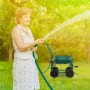 Frau gießt mit Gartenschlauch, aufgewickelt auf grünem Relaxdays Metall Schlauchwagen.