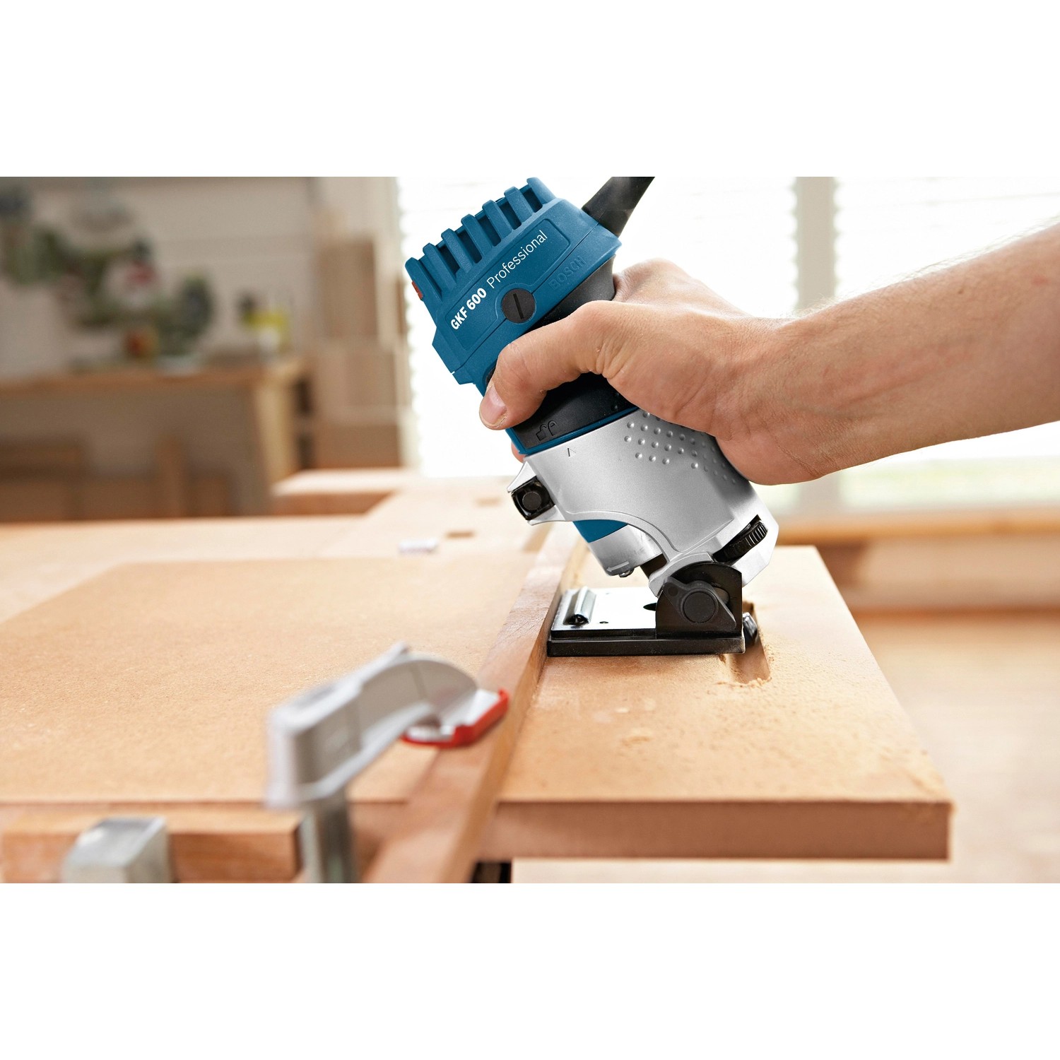 Bosch Professional GKF 600 Kantenfräse in Aktion beim Fräsen einer Holzkante.