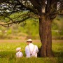 Szene: Vater und Sohn sitzen unter Baum mit Relaxdays Nistkasten aus Tannenholz.