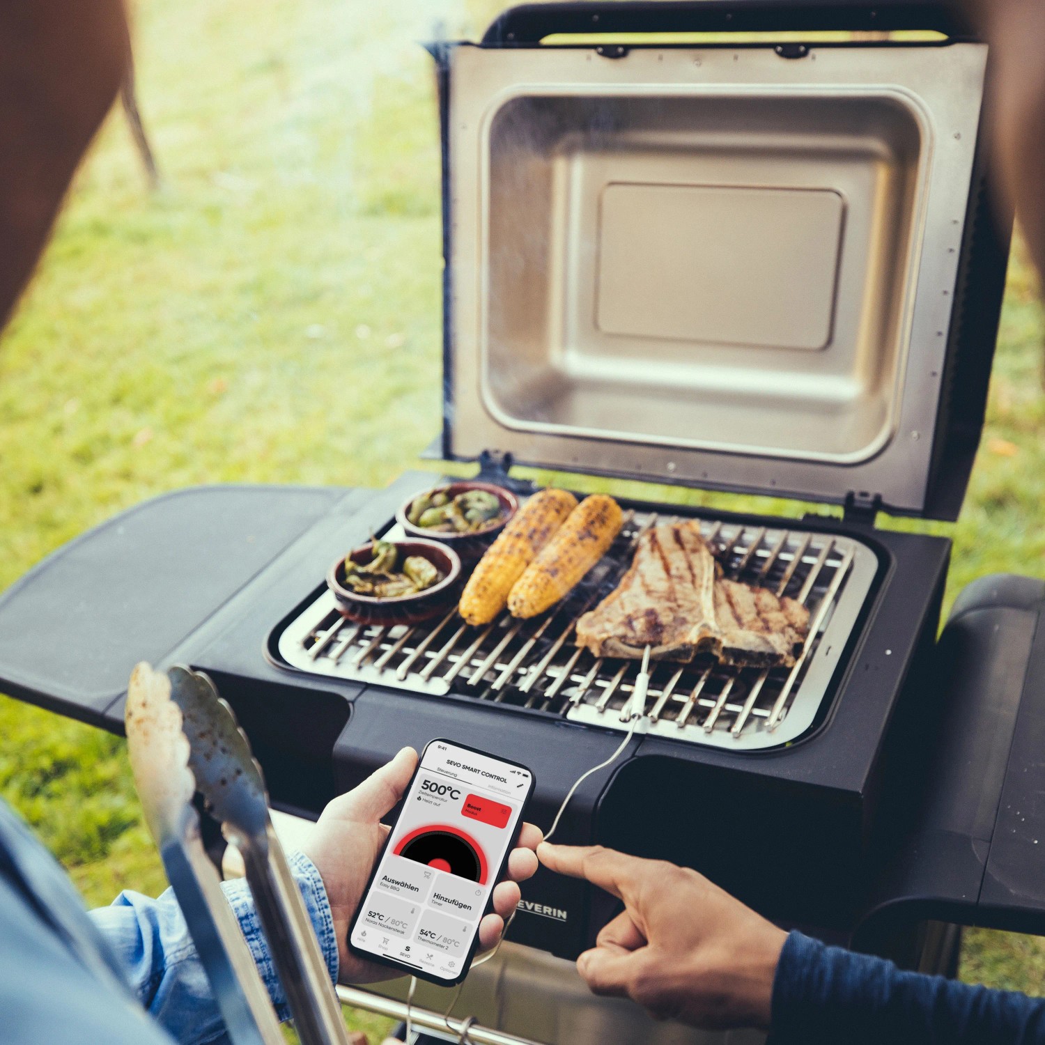 Severin Standgrill PG 8139 mit App-Steuerung, Grillgut und Zubehör auf dem Grillrost.